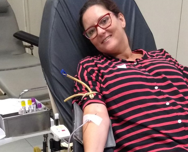 Servidora na cadeira durante doação de sangue